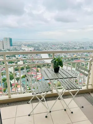 a table with a potted plant sitting on top of a balcony at Vincondotel Near BGC Fairlane in Manila