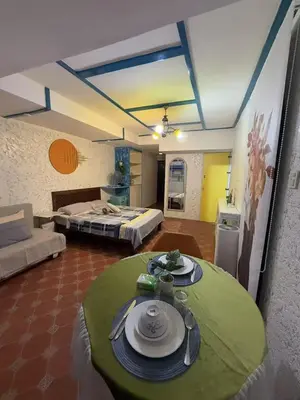 a room with two beds and a table with plates on it at Vincondotel Roxas Ave Manila 1BR Marbella in Manila