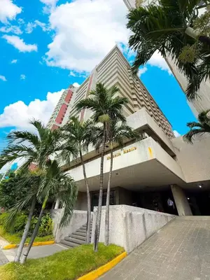 a building with palm trees in front of it at Vincondotel Roxas Ave Manila 1BR Marbella in Manila