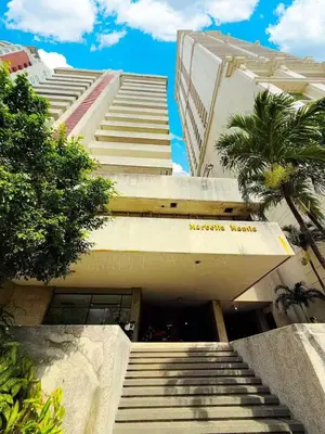 a building with stairs leading up to a building with palm trees at Vincondotel Roxas Ave Manila 1BR Marbella in Manila