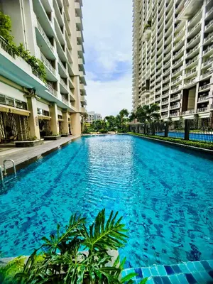 a large blue swimming pool with two tall buildings at Vincondotel Near BGC 2BR Fairlane in Manila