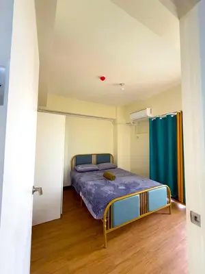 a bedroom with a bed with a blue comforter at Vincondotel Near BGC 2BR Fairlane in Manila