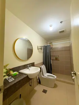 a bathroom with a toilet and a sink and a mirror at Vincondotel Near BGC 2BR Fairlane in Manila
