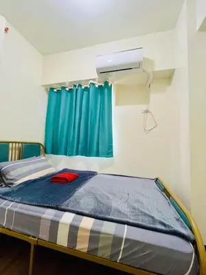 a bed in a room with a blue curtain at Fairlane Residences in Manila