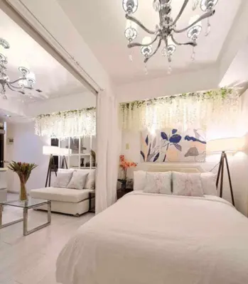 a bedroom with a large white bed and a chandelier at Azure Urban Residences by Lyn in Manila