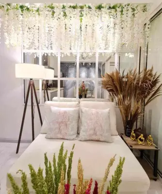a bedroom with a bed with white curtains and plants at Azure Urban Residences by Lyn in Manila