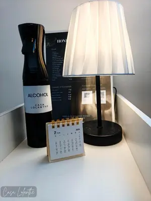 a desk with a lamp and a calendar and a bottle of alcohol at Casa Lolanthe Fully Furnished Studio Unit in Pasong Bayog