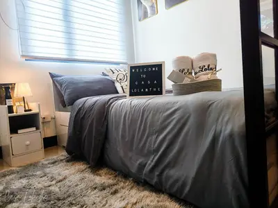 a bedroom with a bed with a clock on it at Casa Lolanthe Fully Furnished Studio Unit in Pasong Bayog