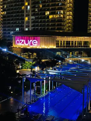 a building with a lit up sign at night at Azure Beach Comfy Cozy Suite in Manila