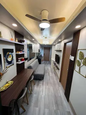a living room with a couch and a table at Stylish and Modern Suite with Pool Access and Parking in Manila