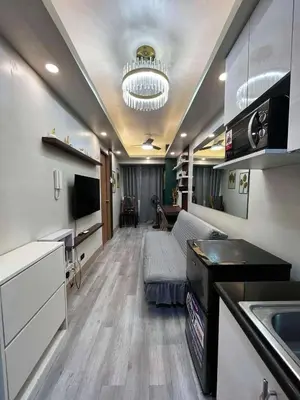a room with a kitchen and a living room at Stylish and Modern Suite with Pool Access and Parking in Manila