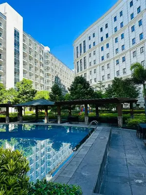 a swimming pool in front of a large building at 81 Newport Blvd Cluster 4 Unit 10C by Rechelle Nunag in Manila