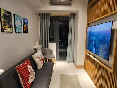 a living room with a couch and a flat screen tv at Best Place For You - Mall of Asia & Airport in Manila