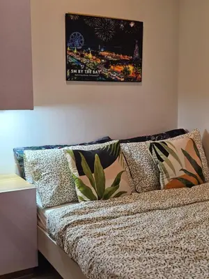 a couch with pillows and a picture on the wall at Best Place For You - Mall of Asia & Airport in Manila