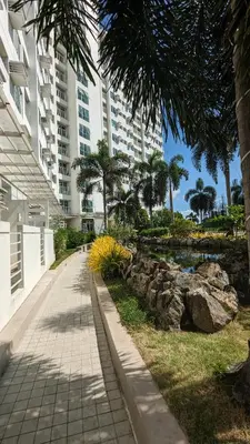 a walkway in front of a building with a pond at Cozy Studio Suite in Muntinlupa in Manila