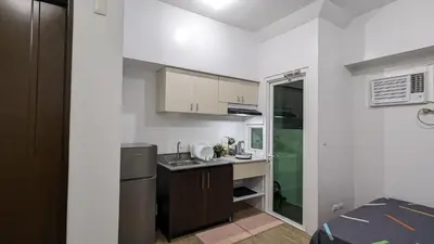 a small kitchen with a sink and a refrigerator at Cozy Studio Suite in Muntinlupa in Manila