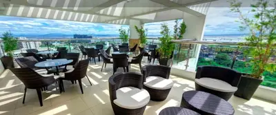 a restaurant with tables and chairs and a large window at Cozy Studio Suite in Muntinlupa in Manila