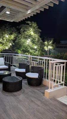 a patio with chairs and tables on a deck at night at Cozy Studio Suite in Muntinlupa in Manila