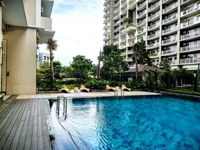 a swimming pool with chairs and a large building at Vincondotel Near BGC 3BR Fairlane in Manila