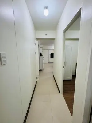 an empty hallway with white walls and a mirror at Vincondotel Near BGC 3BR Fairlane in Manila