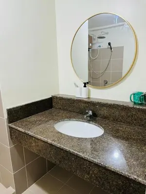 a bathroom counter with a sink and a mirror at Vincondotel Near BGC 3BR Fairlane in Manila