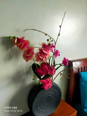 a vase with pink flowers sitting on a table at Sonia Suite at The Beacon Makati in Manila