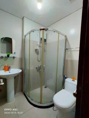 a bathroom with a shower and a toilet and a sink at Sonia Suite at The Beacon Makati in Manila