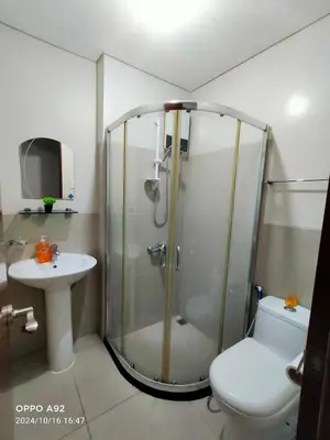 a bathroom with a shower and a toilet and a sink at Sonia Suite at The Beacon Makati in Manila