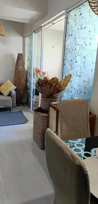a living room with chairs and a table and a window at Azure Urban Residences By Lyn 2BR in Manila
