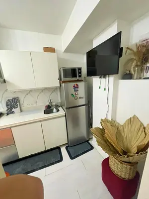 a small kitchen with a refrigerator and a sink at Azure Urban Residences By Lyn 2BR in Manila