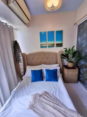a bedroom with a large bed with blue pillows at Azure Urban Residences By Lyn 2BR in Manila
