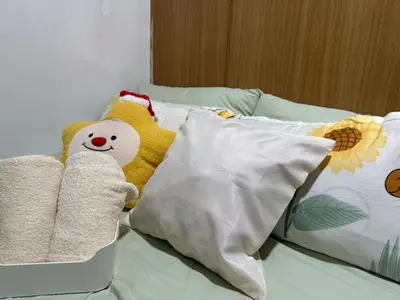 two stuffed animals sitting on a bed with pillows at Shell Residence Condotel in Manila