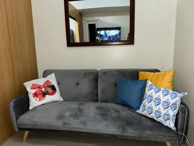 a couch with pillows on it in a living room at Shell Residence Condotel in Manila