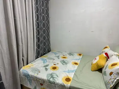a small bed with a floral sheet and two pillows at Shell Residence Condotel in Manila
