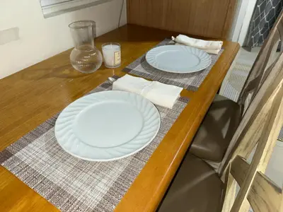 two white plates sitting on a wooden table at Shell Residence Condotel in Manila