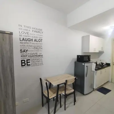 a kitchen with a table and two chairs and a refrigerator at Budget Family Group Room for 4 persons in Manila