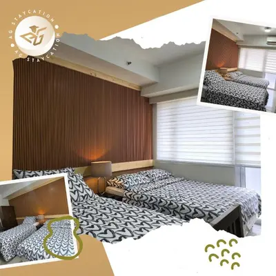 a bedroom with two beds with black and white sheets at Deluxe Room with Balcony near MOA in Manila