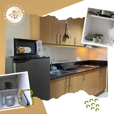 a kitchen with a sink and a microwave at Deluxe Room with Balcony near MOA in Manila