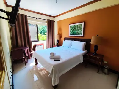 a bedroom with a large white bed and a window at Spring Plaza Hotel in Dasmariñas