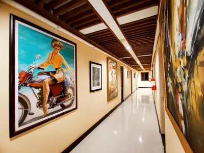 a hallway with a painting of a woman riding a scooter at Spring Plaza Hotel in Dasmariñas