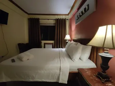 a hotel room with a bed and a table with a lamp at Spring Plaza Hotel in Dasmariñas
