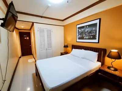 a bedroom with a bed and a flat screen tv at Spring Plaza Hotel in Dasmariñas
