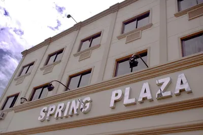 a white building with a sign on top of it at Spring Plaza Hotel in Dasmariñas