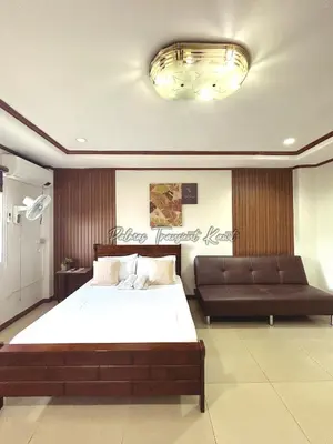 a bedroom with a large bed and a couch at Palmas Transient Kawit in Kawit
