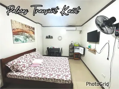 a bedroom with a bed and a sign on the wall at Palmas Transient Kawit in Kawit