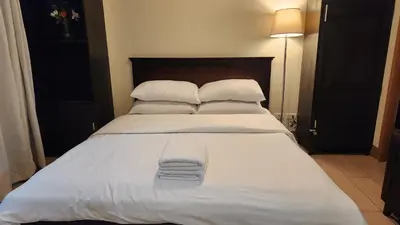 a large bed with white sheets and pillows at Casa Antonio at 7i Two Palm Tree Villas Beside NAIA3 in Manila