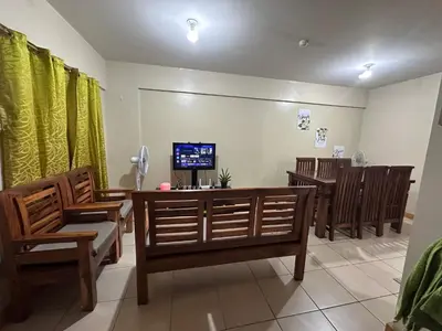 a waiting room with chairs and a tv on the wall at Homey Staycation in Taguig in Manila