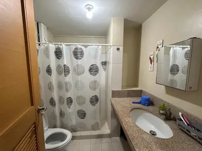 a bathroom with a shower and a toilet and a sink at Homey Staycation in Taguig in Manila