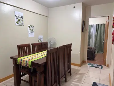 a dining room with a wooden table and chairs at Homey Staycation in Taguig in Manila