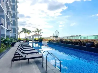 a swimming pool with lounge chairs next to a building at Condo next door in Manila